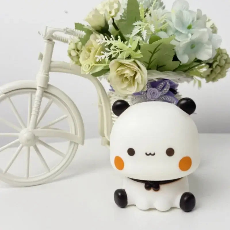 Bubu and Dudu lamp design with a cute ghost character beside a decorative bicycle and flowers.