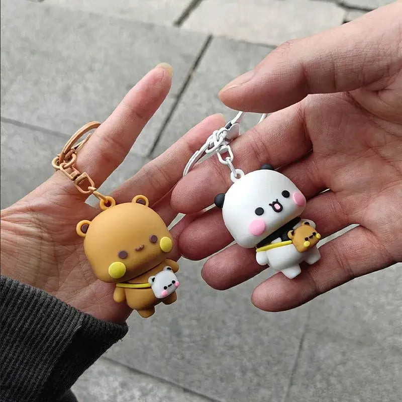 Bubu and Dudu couple keychain held in hands, featuring a brown bear and a white panda, symbolizing love and friendship.