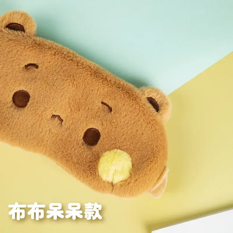 Bubu and Dudu eye cover in plush fabric, featuring a cute bear design with brown and yellow accents.