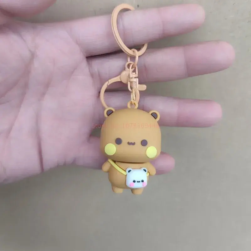 Hand holding a cute Bubu and Dudu couple keychain featuring a bear and panda design.