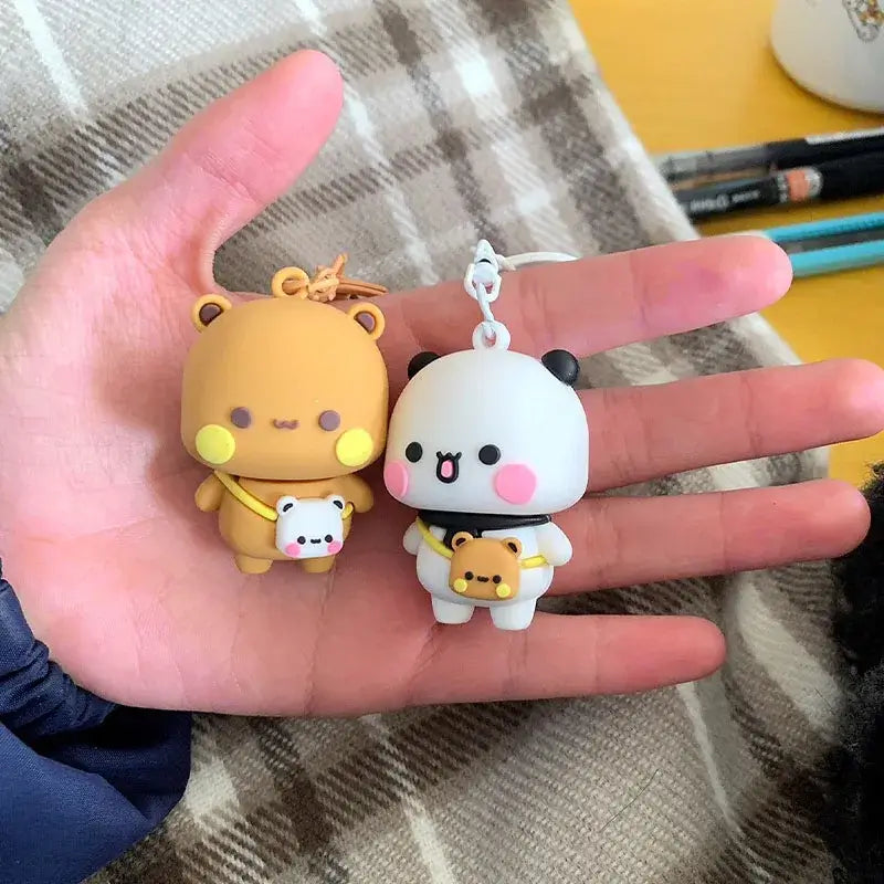 Cute Bubu and Dudu couple keychains featuring a bear and panda in a hand, showcasing their adorable design.